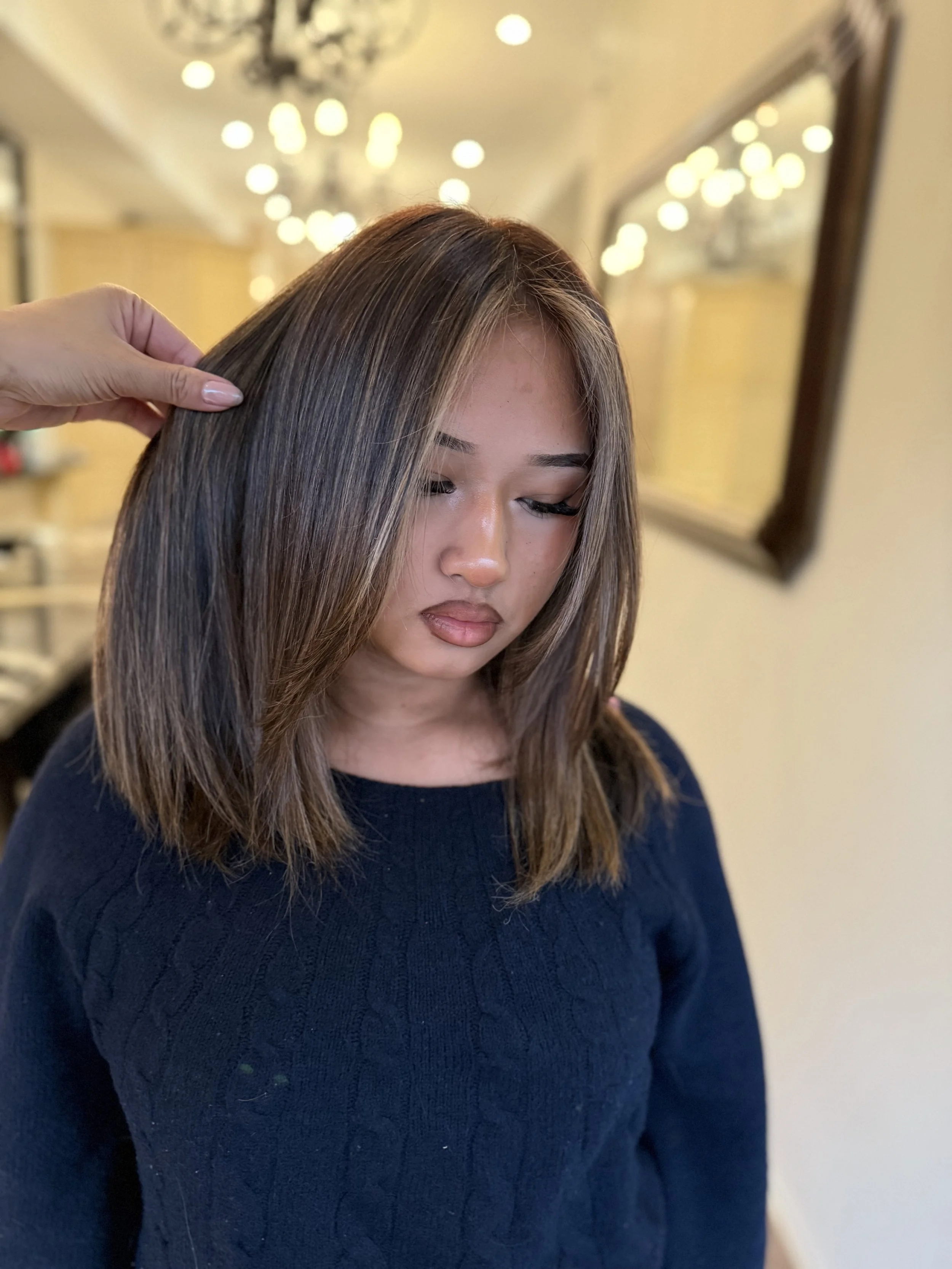 Close-up of wavy blonde hair with highlights.