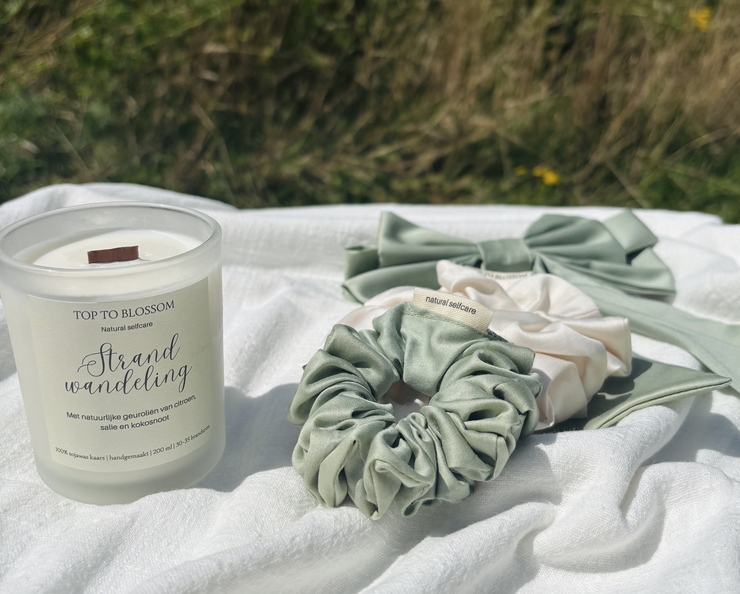 Een bedekt pakket met een geel en wit bloemenpatroon en een label dat zegt 'TOP TO BLOSSOM, natural selfcare'.