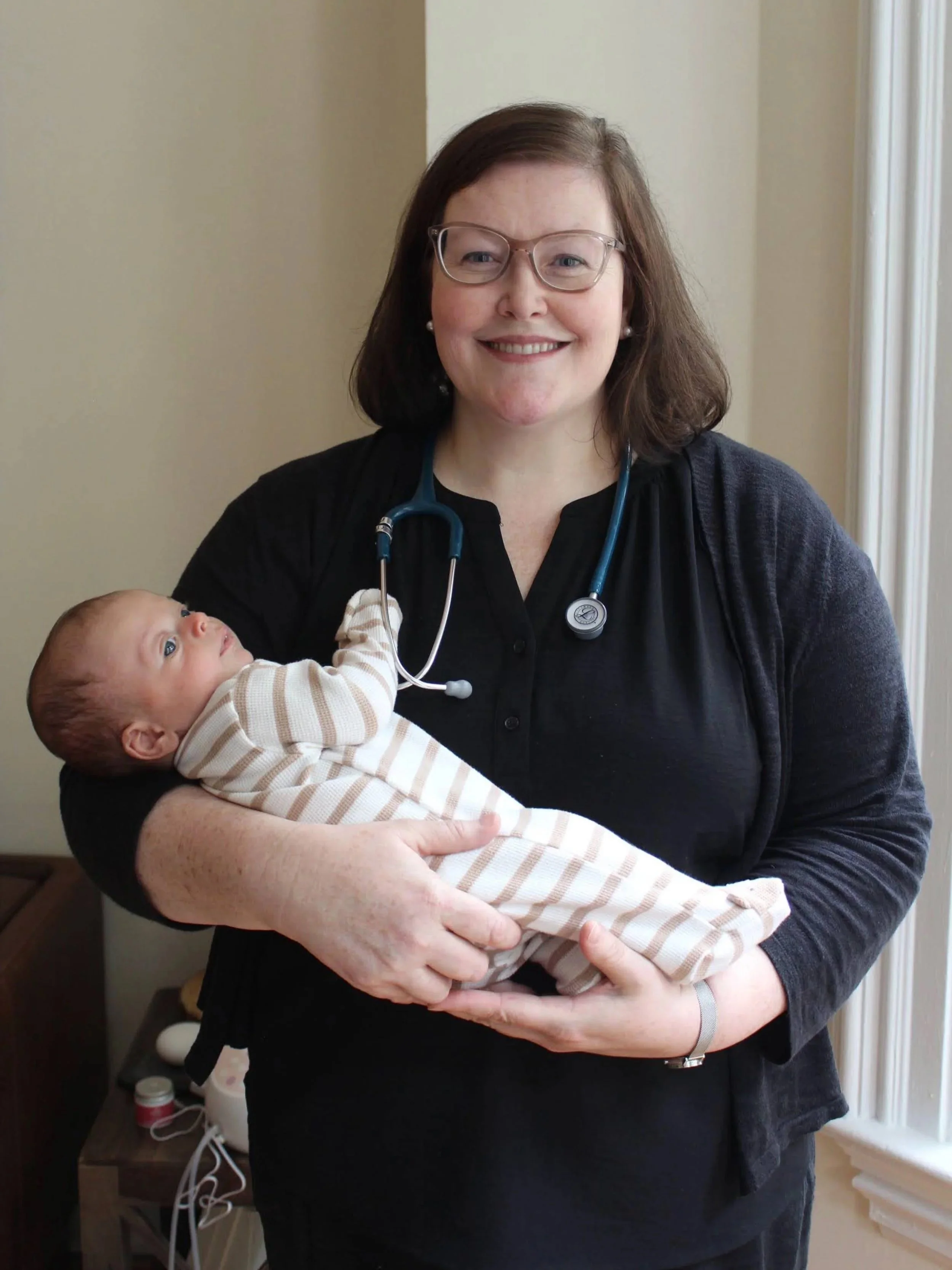 A nurse holds a newborn baby