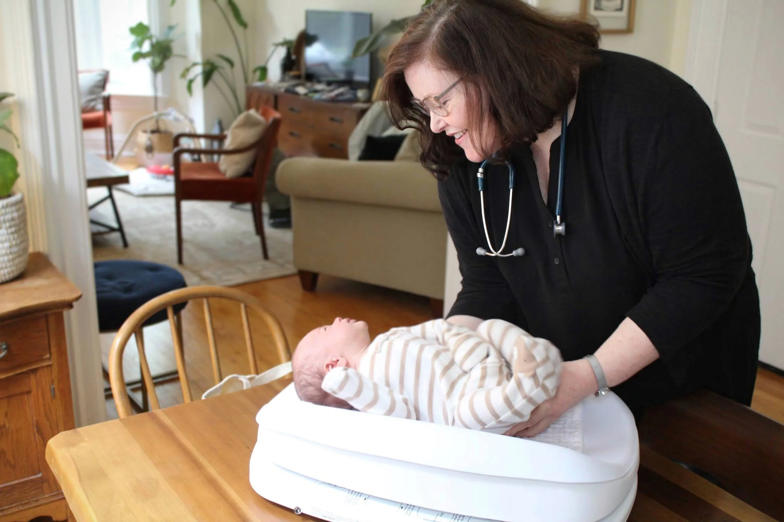 a woman places a baby on a scale