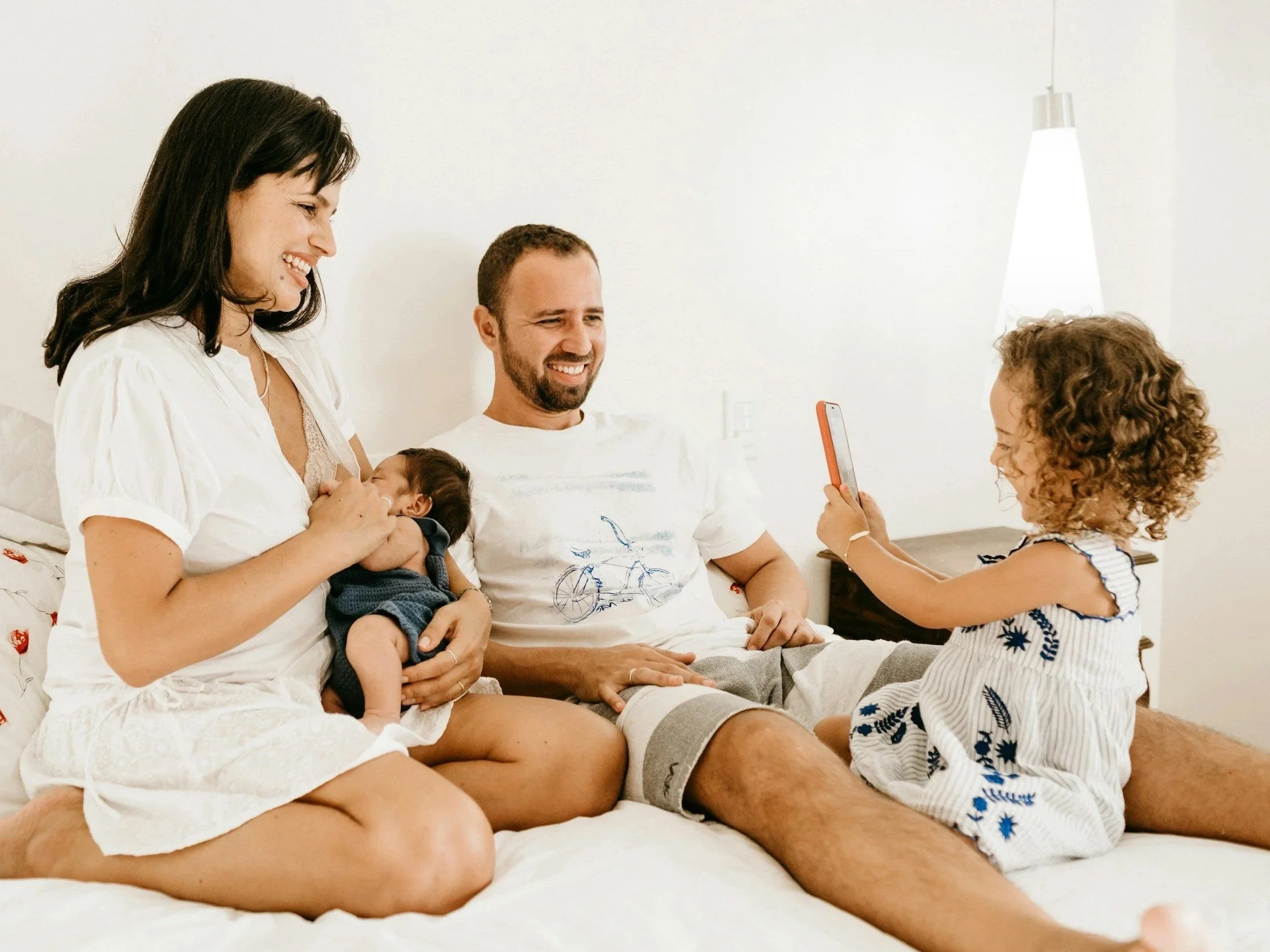 a family plays together with a newborn infant