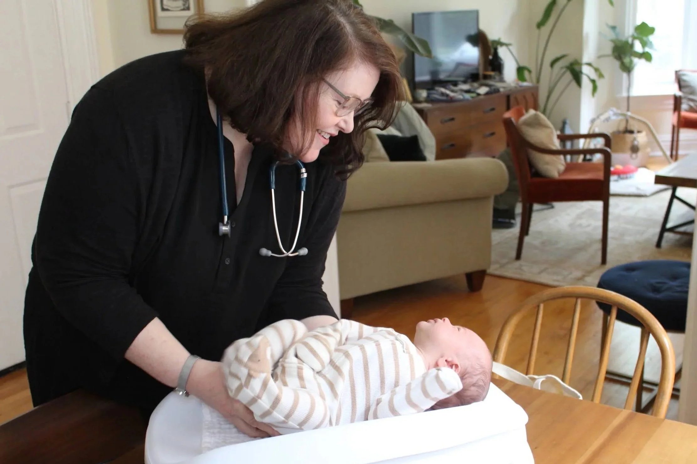 A nurse sets a newborn baby on a scale