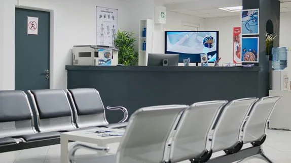 Recepção da clínica com balcão de atendimento e cadeiras da sala de espera