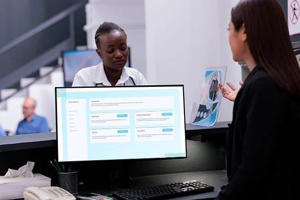 Atendente de clínica usando o sistema Chiko no computador para confirmar consultas e reduzir no-show