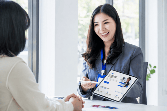 Recepcionista de clínica atendendo paciente com apoio de um agente de IA no tablet para reduzir o turnover na clínica
