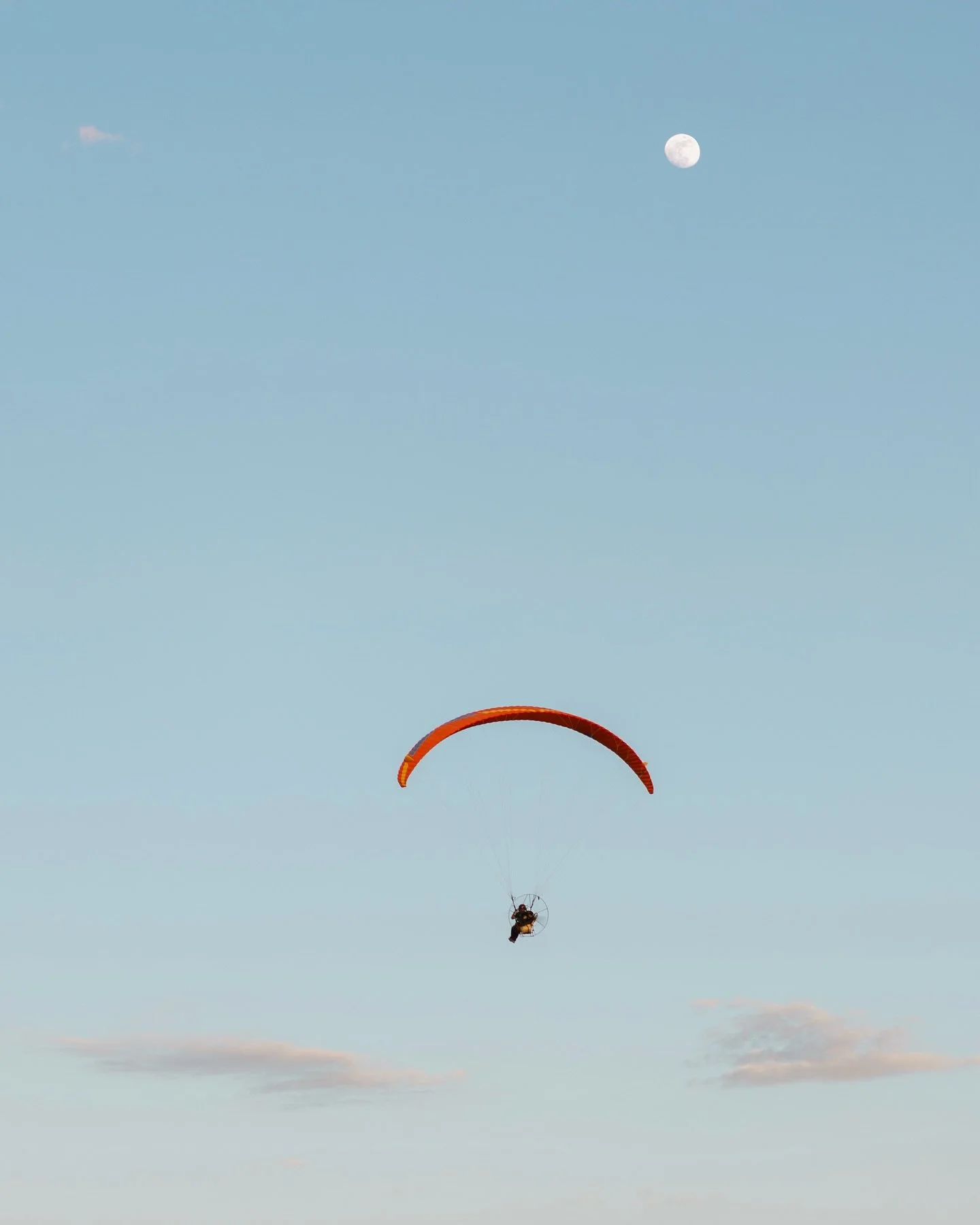 Throwing it back to our time in Moab, Utah! Looked out the window one evening and saw these two flying by. 🪂 
Would you ever paraglide?! Personally, I could never see myself doing it because I am terrified of heights. But at the same time I’m