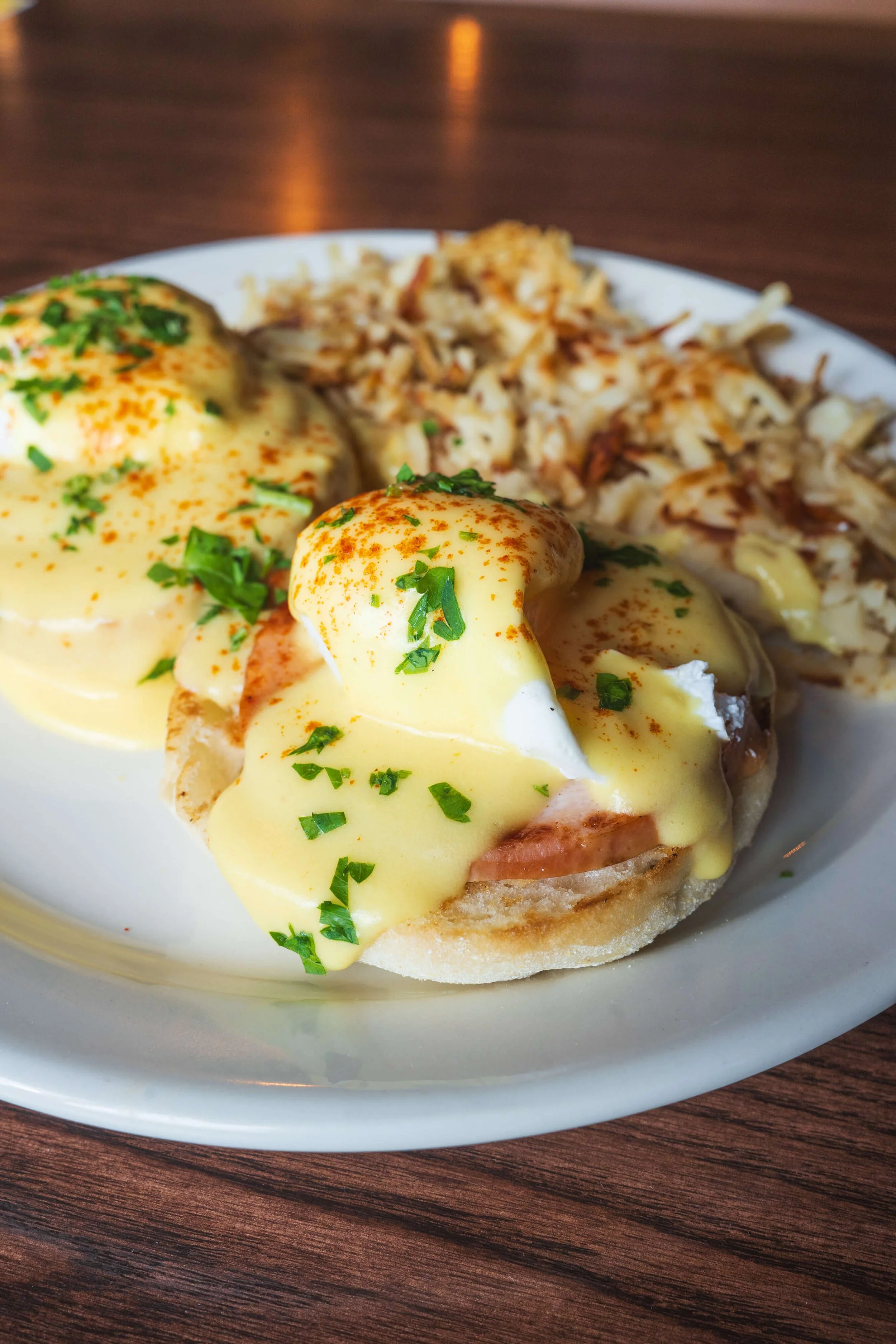 Eggs Benedict with ham, poached eggs, hollandaise sauce, and crispy hashbrowns at Uncle Bill’s