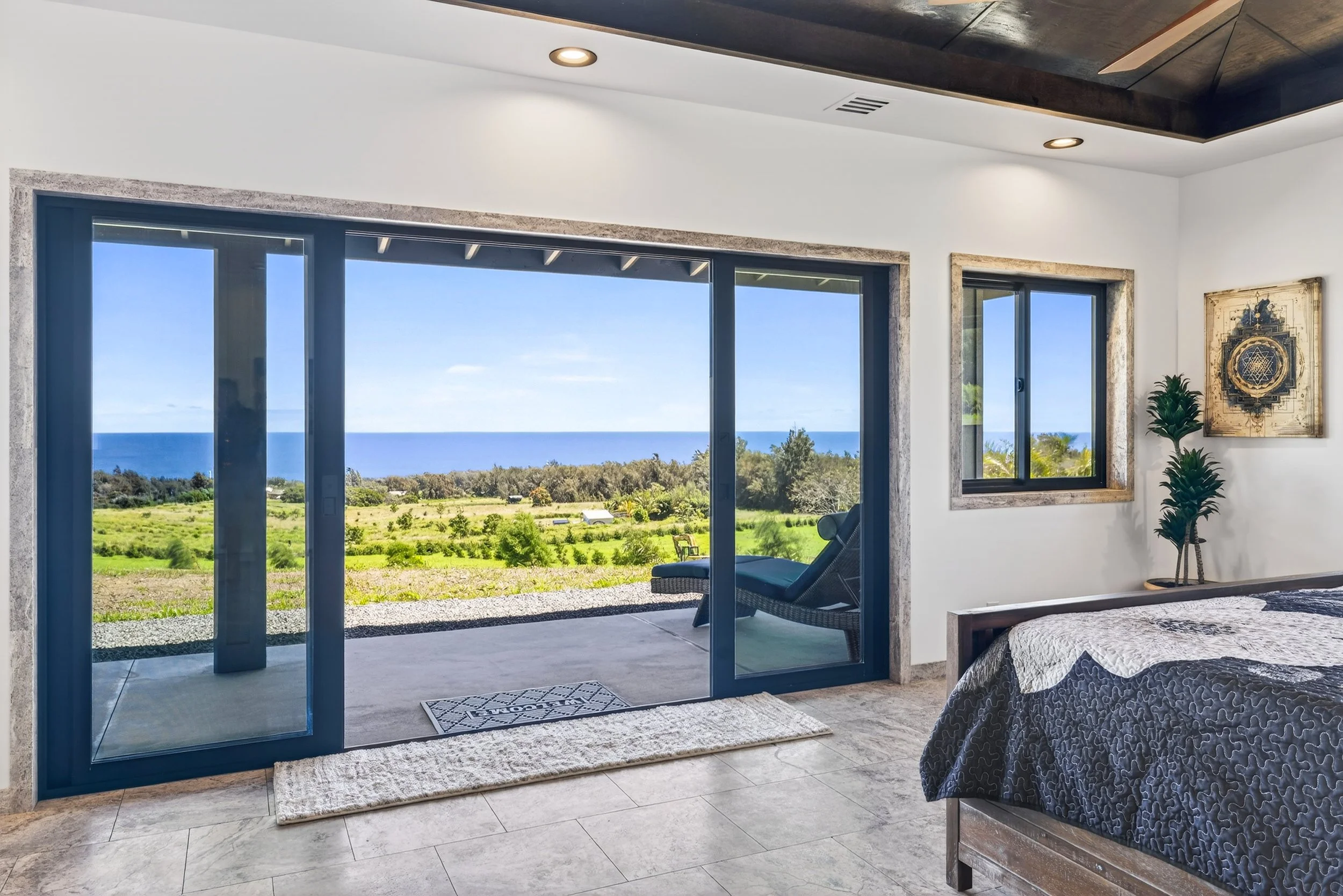 Ocean view bedroom with private patio access at Stargate Farm Big Island Hawaii vacation rental