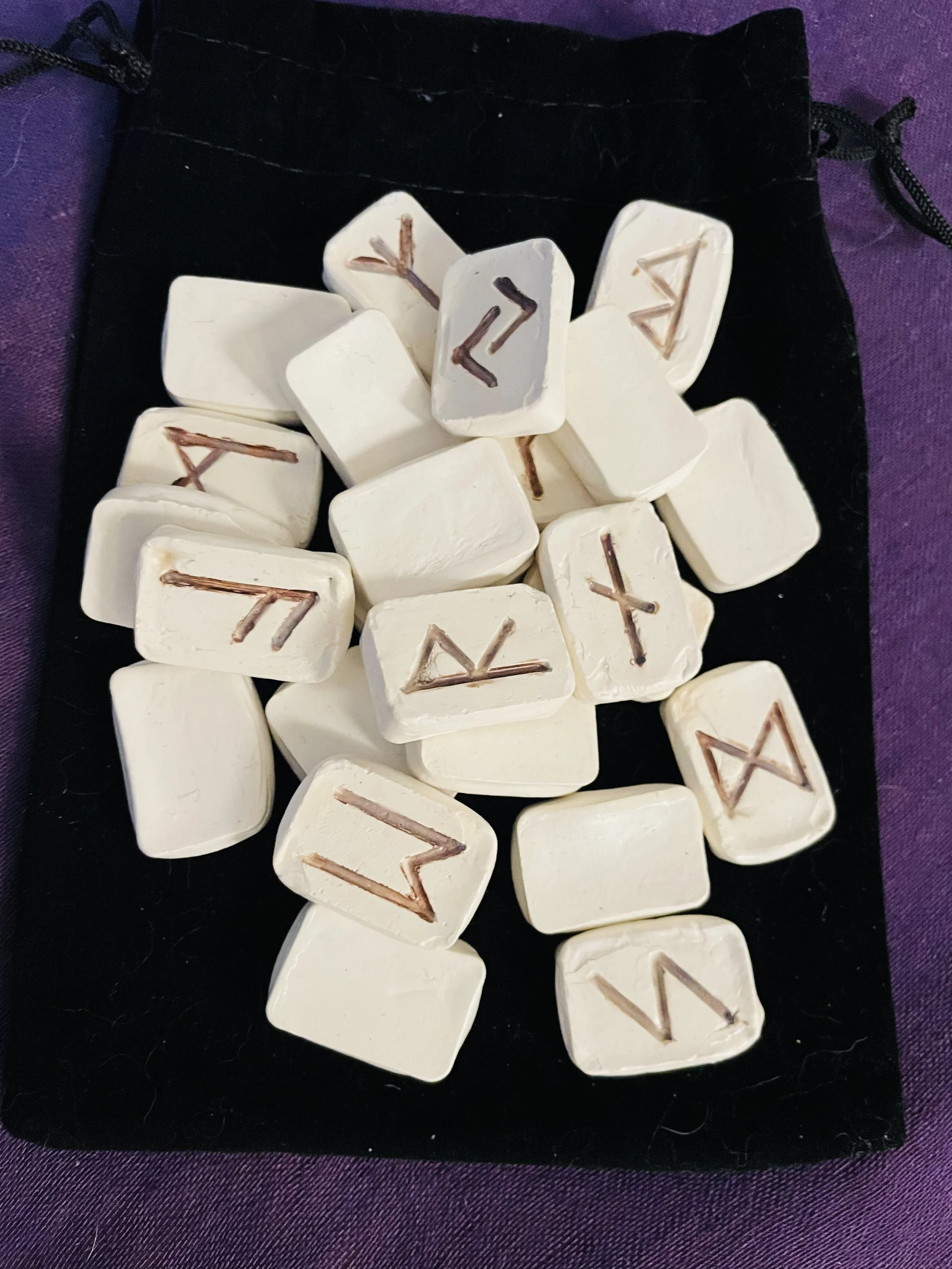 Handcrafted Elder Futhark rune set of clay with 24 runes plus a blank rune, for divination and spiritual practice.