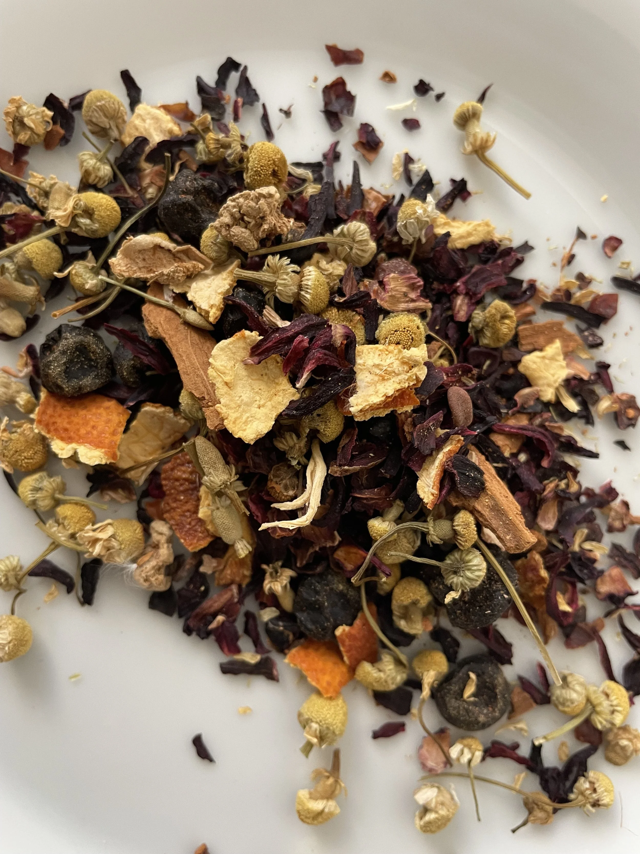 Loose leaf hibiscus herbal tea ingredients including hibiscus petals, chamomile, orange peel, rose hips, blueberries, cinnamon, and ginger