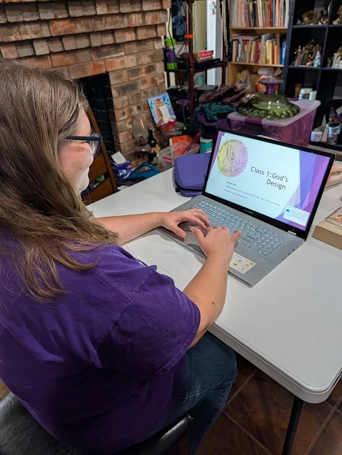 Childbirth educator Melanie Powell sitting at her laptop ready to teach class 1 via live virtual zoom