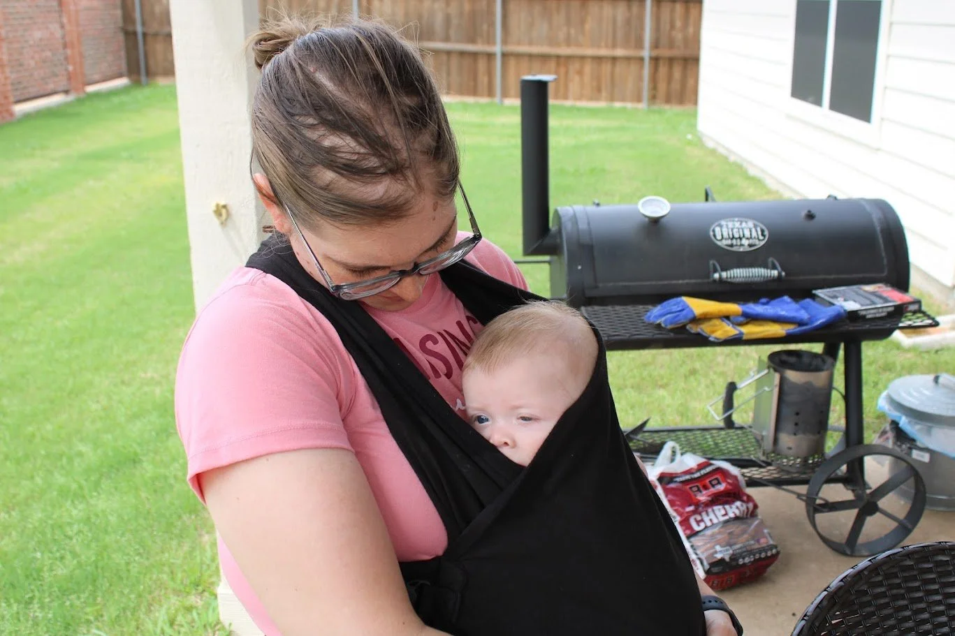 Doula Melanie Powell babywearing her new baby outside their Mansfield home