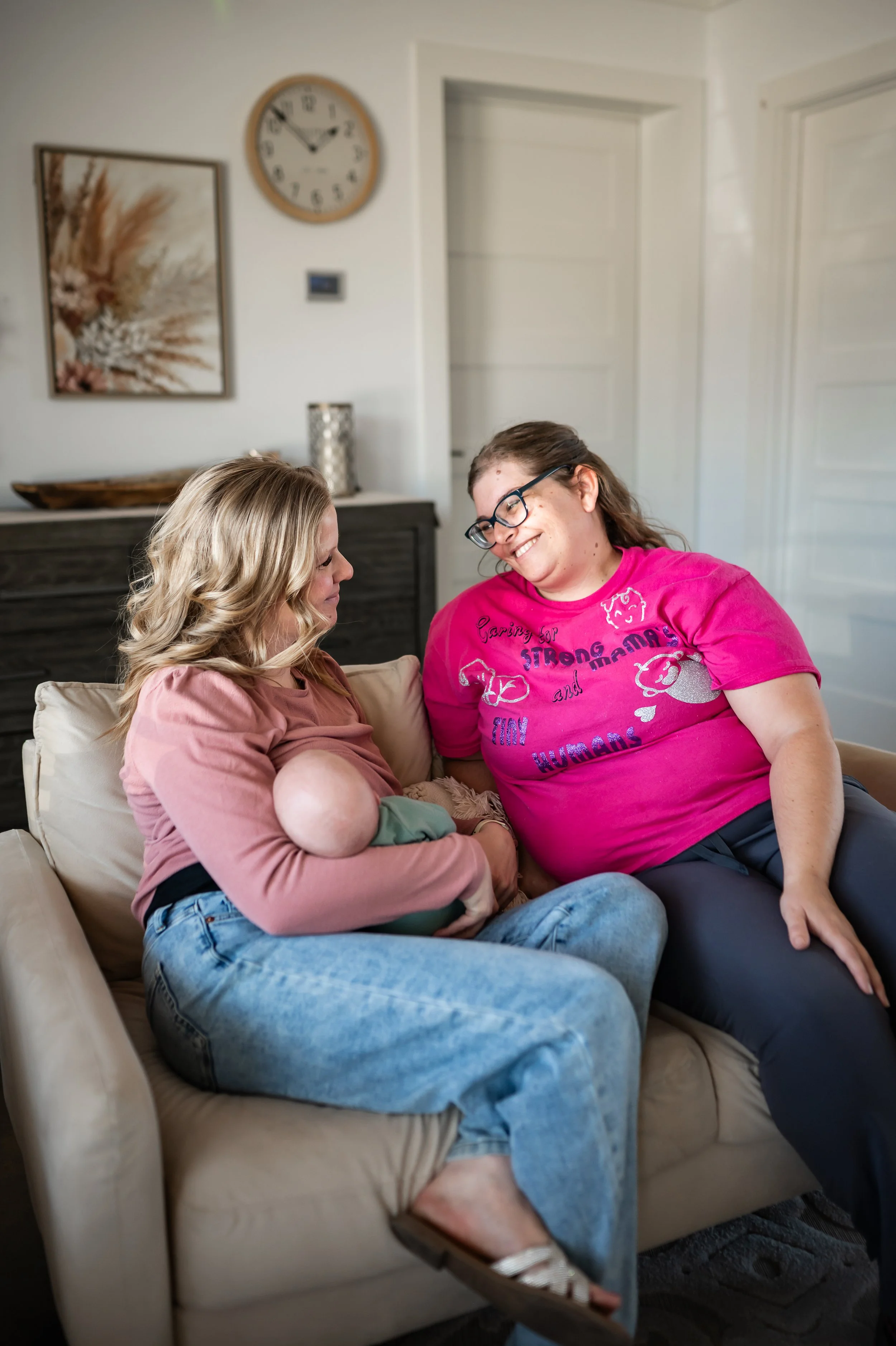"Doula Melanie Powell smiling as she chats with a new mom providing emotional, and spiritual support."