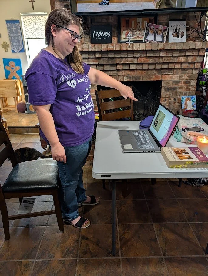 Doula Melanie Powell standing in her home teaching virtual participants comfort measures for labor