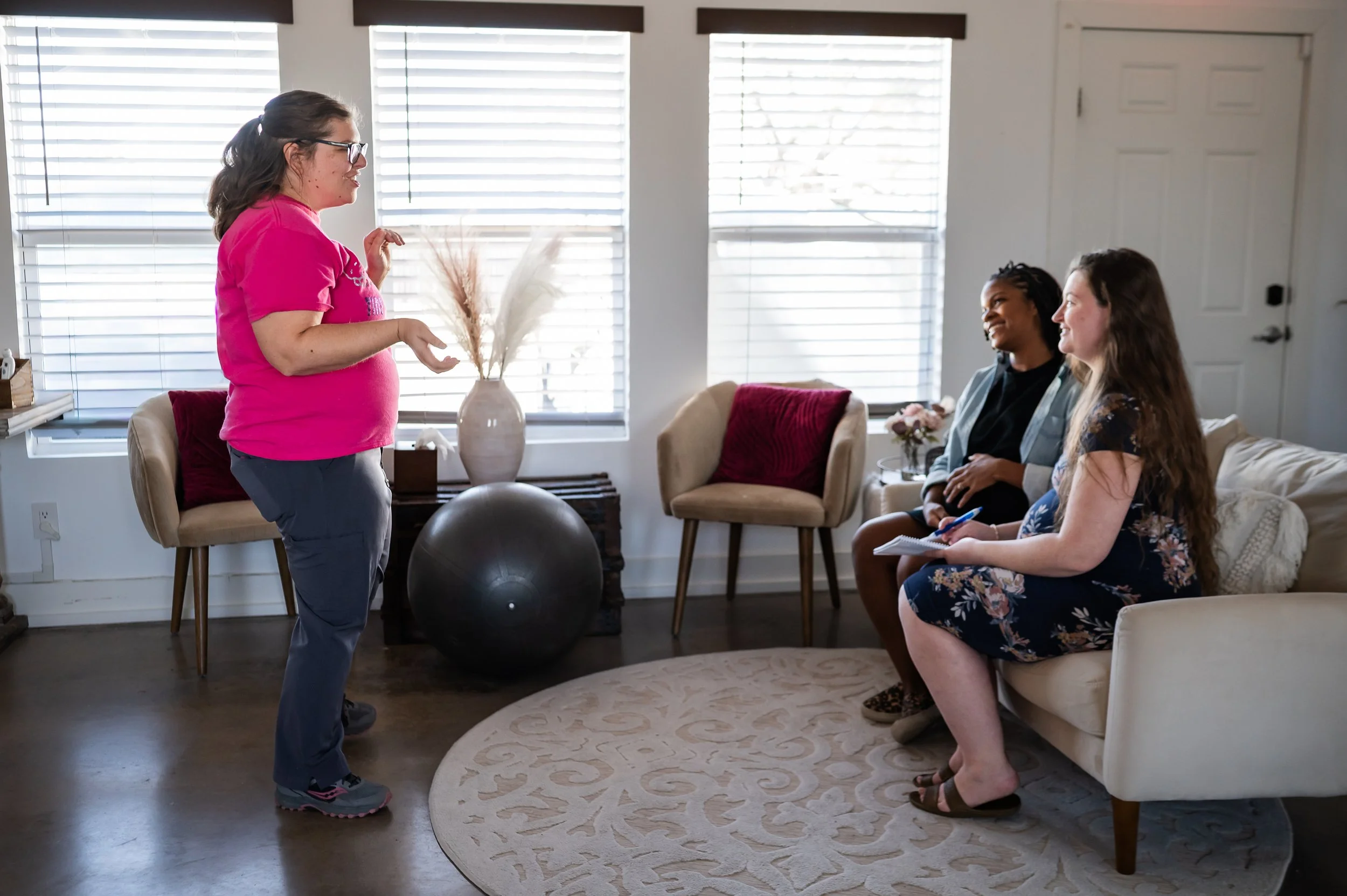 Melanie Powell standing in front of pregnant moms teaching about labor and postpartum.