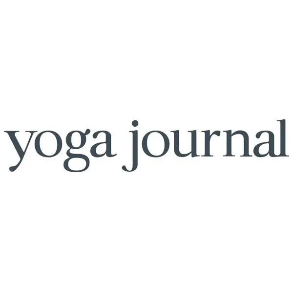 The image displays the words 'yoga journal' in lowercase letters with a simple, elegant font on a white background.