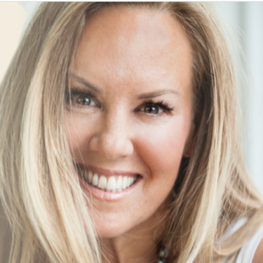 Close-up of a smiling woman with long blonde hair.