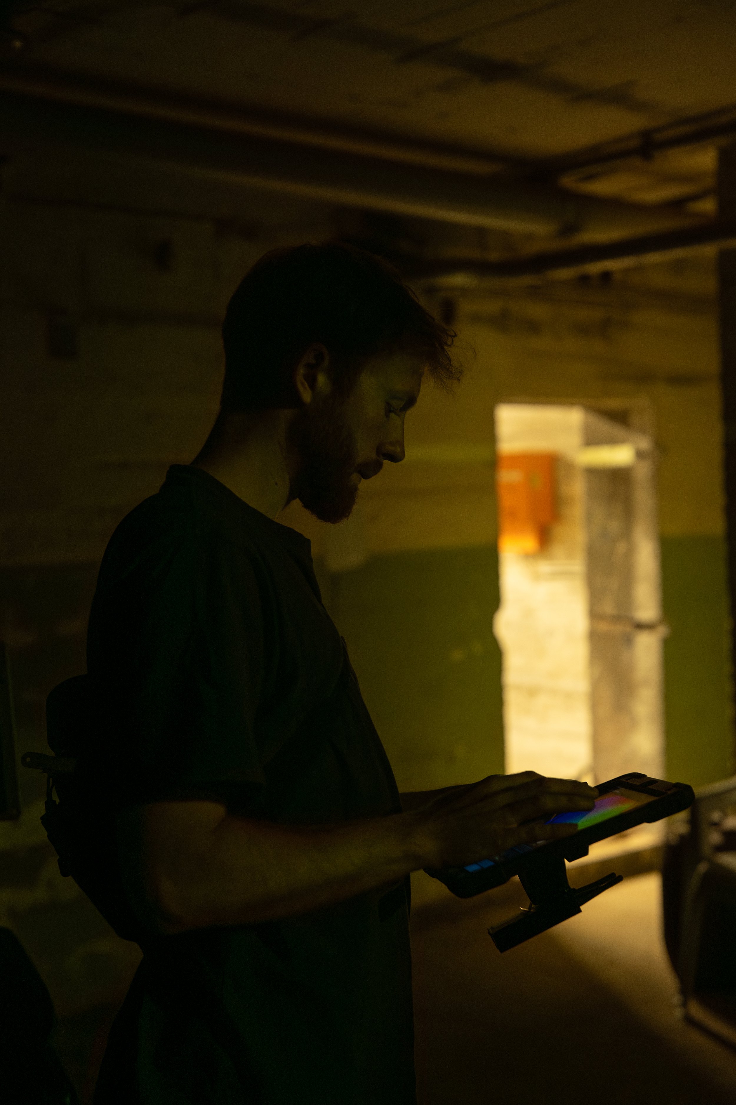 Ein Mann benutzt ein elektronisches Musikinstrument in einem dunklen Raum.