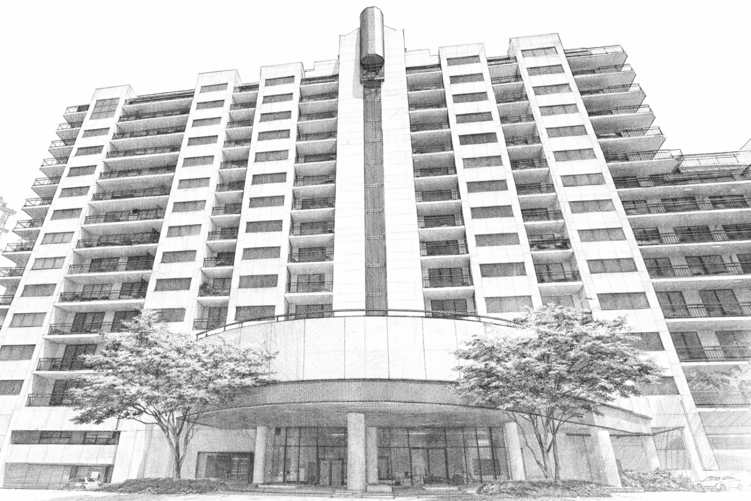 A tall modern apartment building with multiple balconies and large glass entrance doors, surrounded by trees.