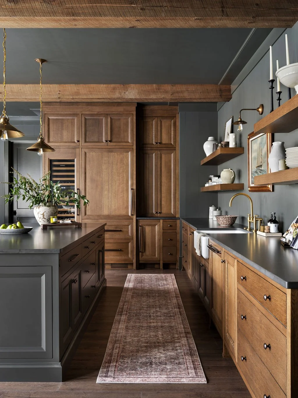 Kitchen with wooden cabinets, open shelves, black countertops, and pendant lighting.