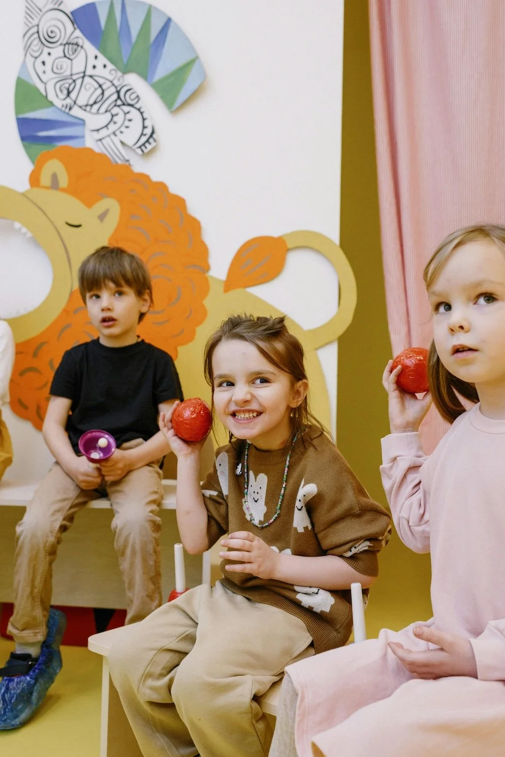 Kinder sitzen im Kreis mit Rasseln in der Hand – fröhliche Musikszene im Workshop für Vorschulkinder