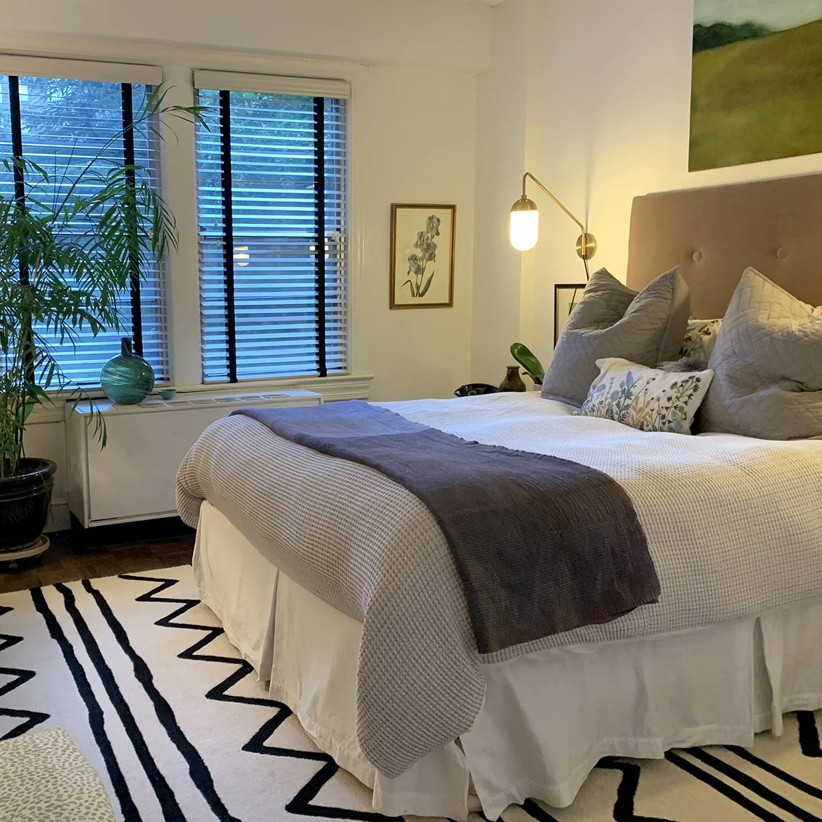 modoern bedroom  with white walls and fabric headboard
