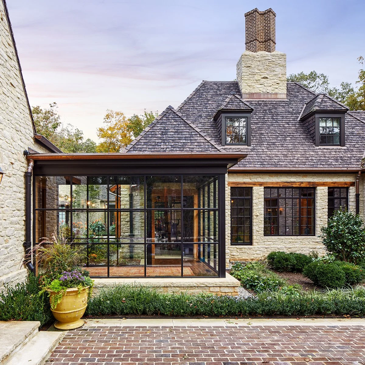 rear exterior of stone house with glassed in patio