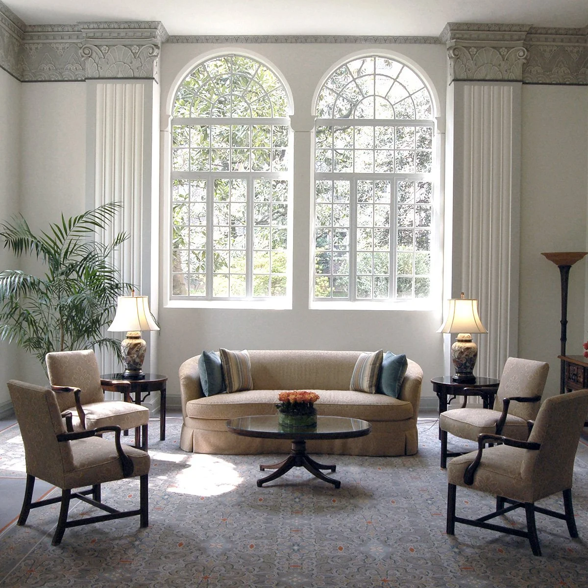 formal living room with antique furniture and high arched windows