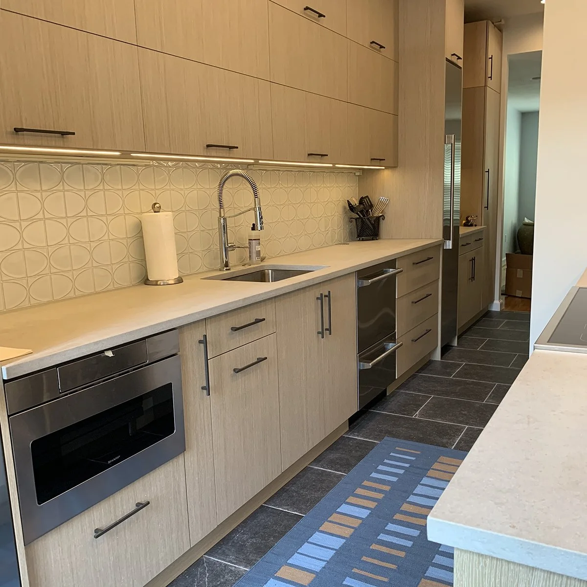 galley kitchen with natural wood, horizontal cabinets