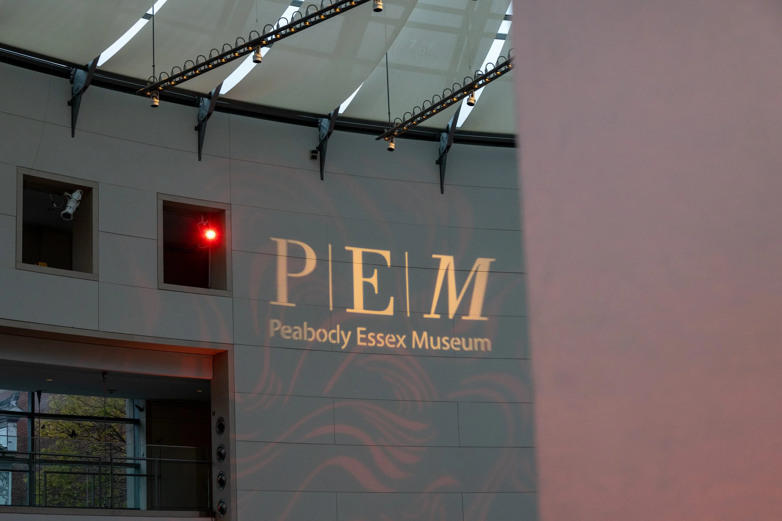 The interior of the Peabody Essex Museum with its logo projected onto a wall.