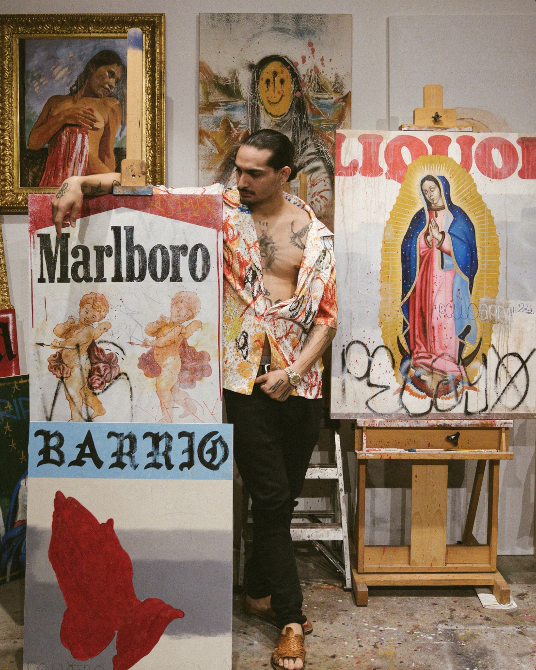 Guy standing next to multiple paintings