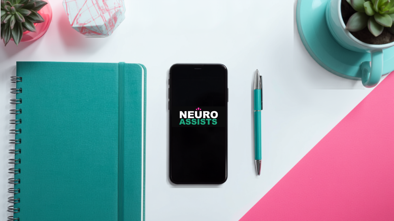 Flat lay of a white desk with a teal notebook, a smartphone displaying 'NEURO ASSISTS,' a teal and silver ballpoint pen, a teal plant pot with a succulent, and a pink cup with a matching saucer, with a pink and white background.