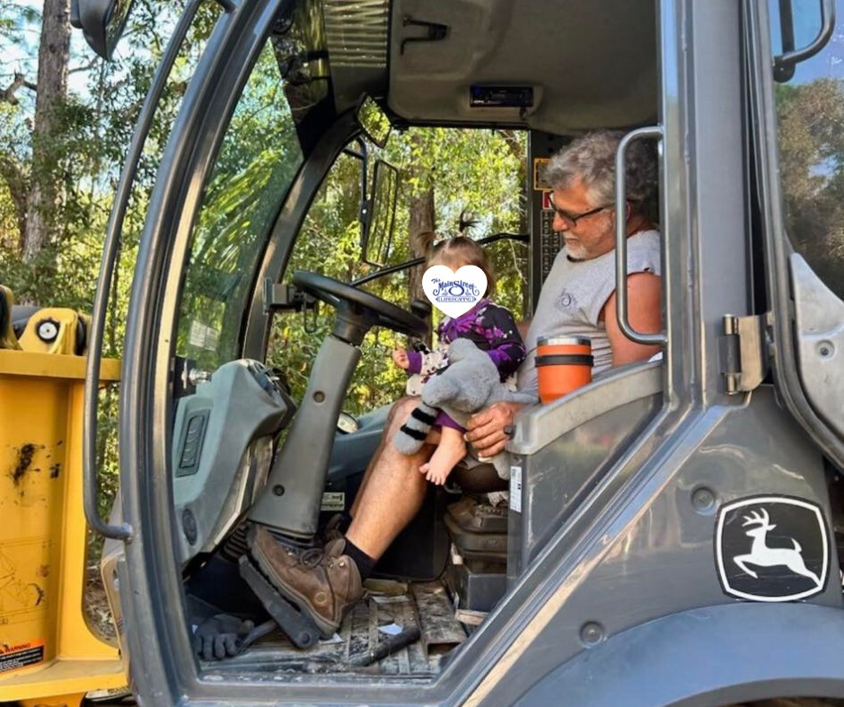 Donald Billick and his grandchild sitting inside a John Deere loader, reflecting the family roots of Main Street Landscaping
