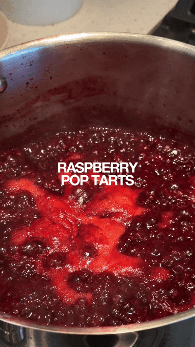 A saucepan with boiling raspberry mixture labeled 'Raspberry Pop Tarts' on top.