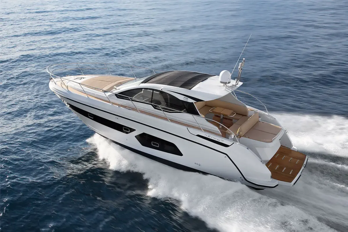 Luxury white yacht with beige seating area, black roof, and wooden deck, cruising on open water.
