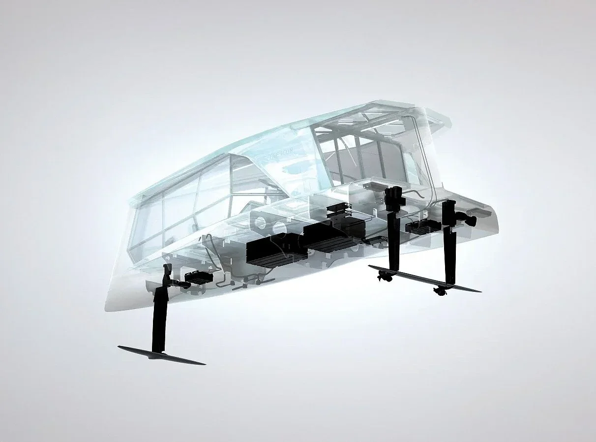 A transparent drone with a sleek, futuristic design. It has a clear acrylic body, black propellers, and visible internal components. The drone is flying against a plain, light background.