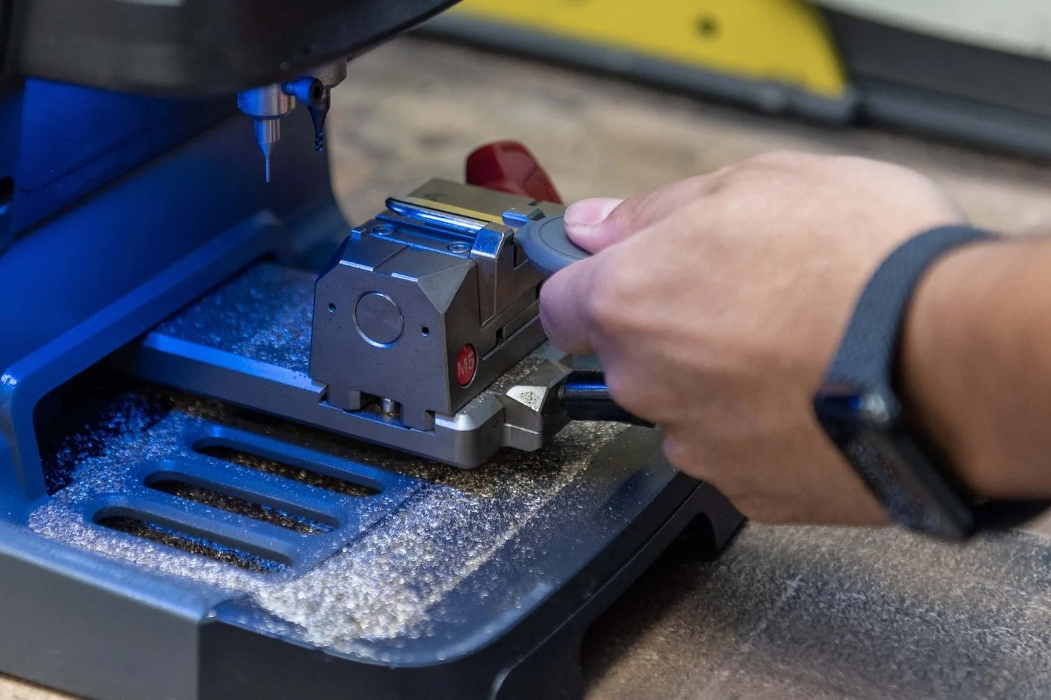 Precision key cutter clamping a key blank on a Locksmith Republic bench