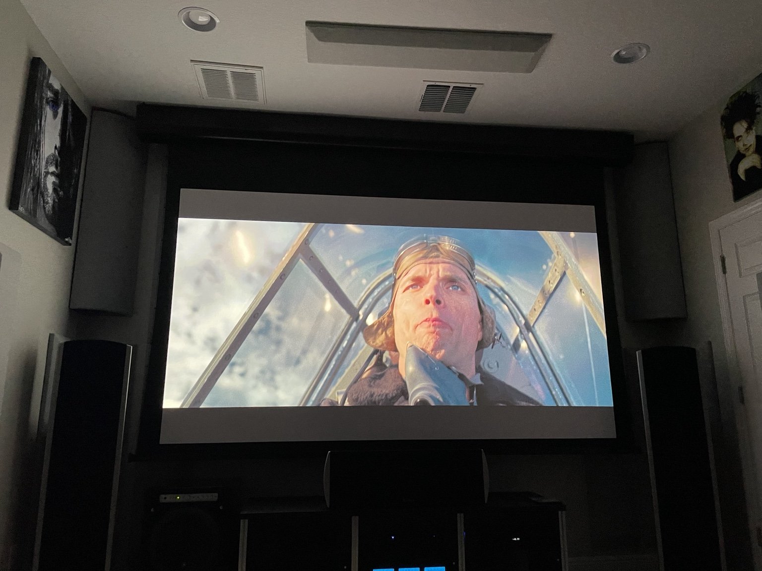 Motorized projection screen in a dedicated home theater in Land O’ Lakes, Florida, with surround speakers and acoustic treatments.
