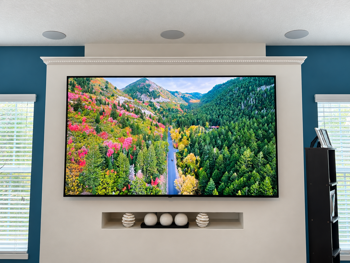 Wall-mounted TV and in-ceiling speakers installed by Precision Smart Home in Riverview, FL.