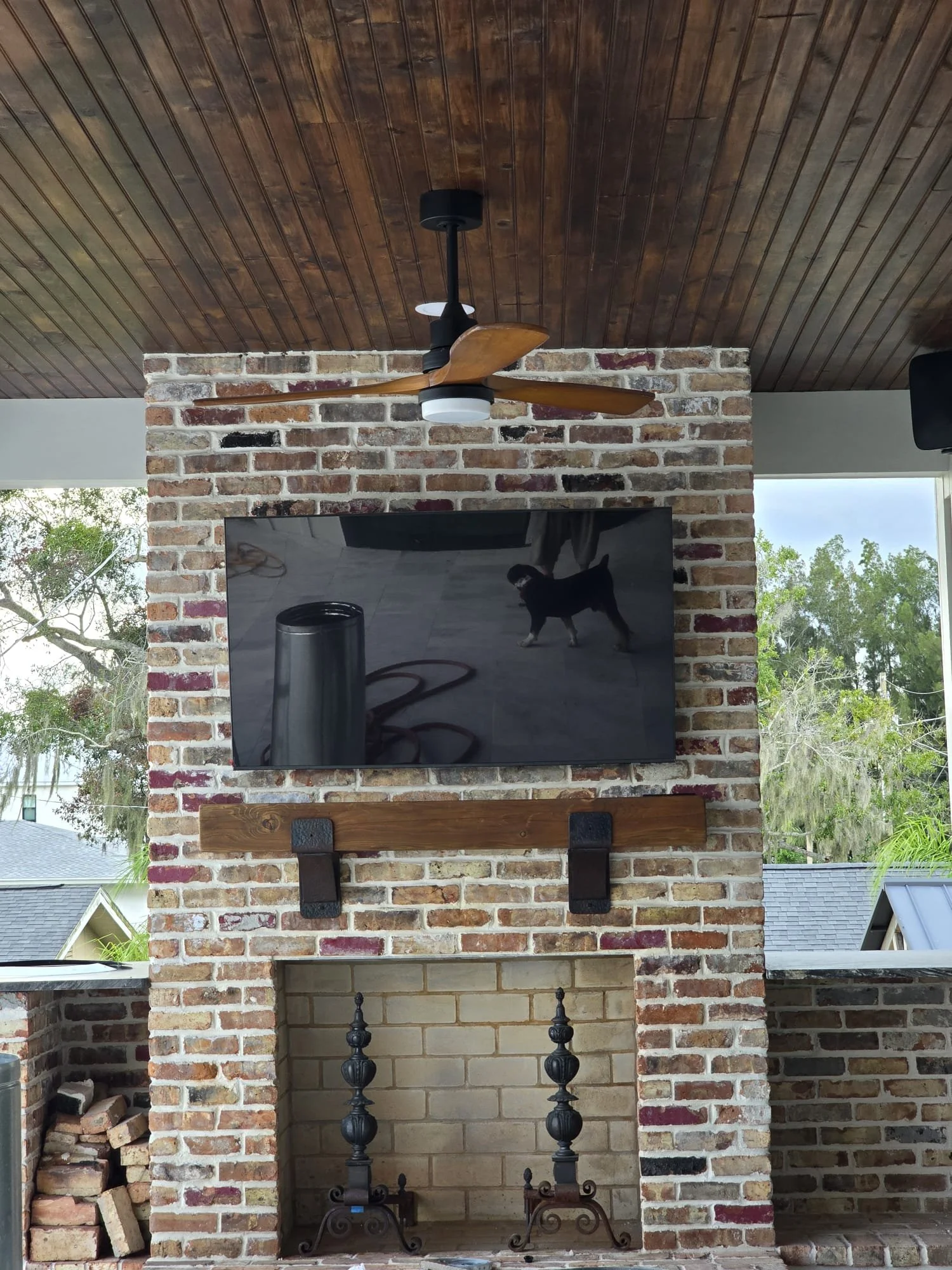 Outdoor TV mounted above a fireplace and connected to a whole-home video system in Ruskin, Florida.