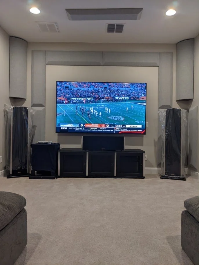 75-inch TV revealed behind a retractable projection screen in a Land O’ Lakes home theater.