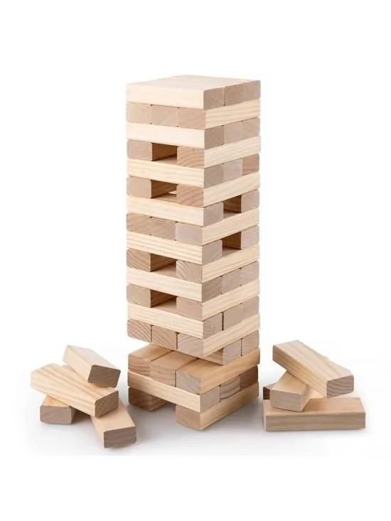 A tall stack of wooden blocks, with additional blocks scattered at the base, used for a game of Jenga.