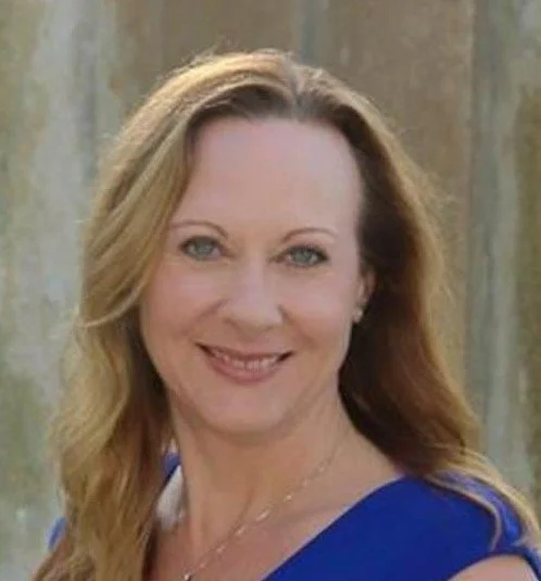 Dr. Christina Frederick, a woman with long, wavy blonde hair smiling and wearing a blue top.