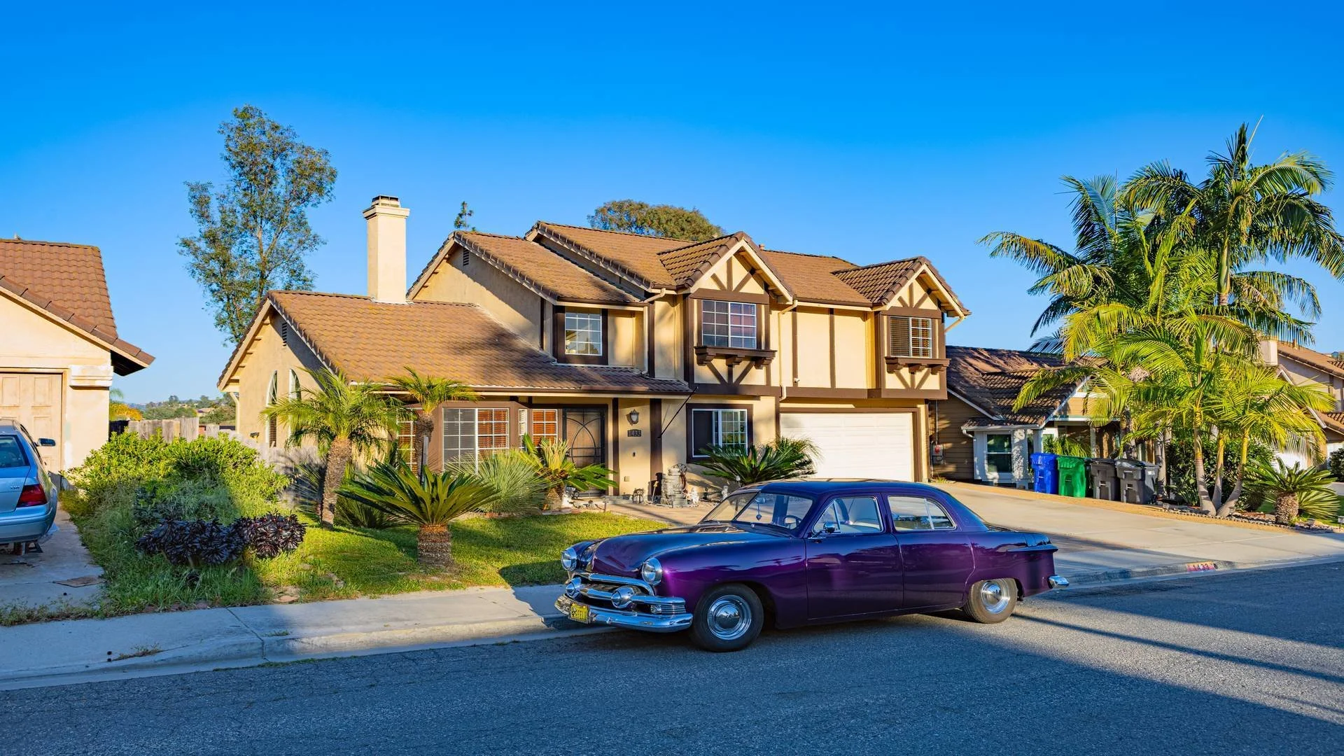 Professional photography for a real estate listing in North San Diego County. There is a purple vintage car parked on the street in front of the house.