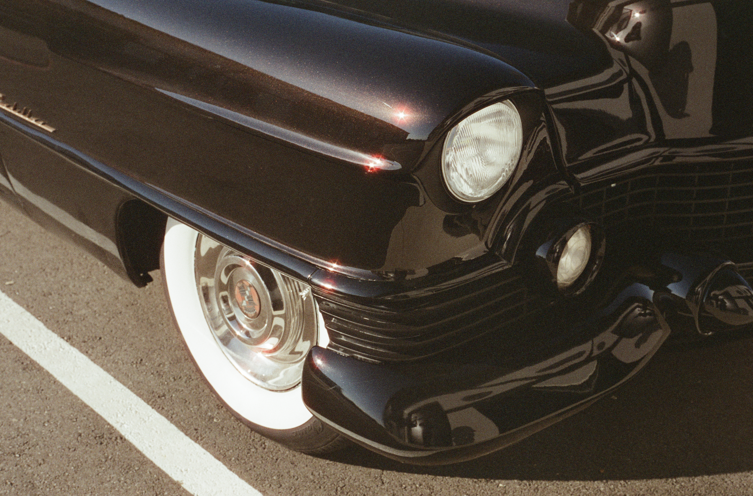 The front passenger wheel and part of the bumper on a 1954 Cadillac