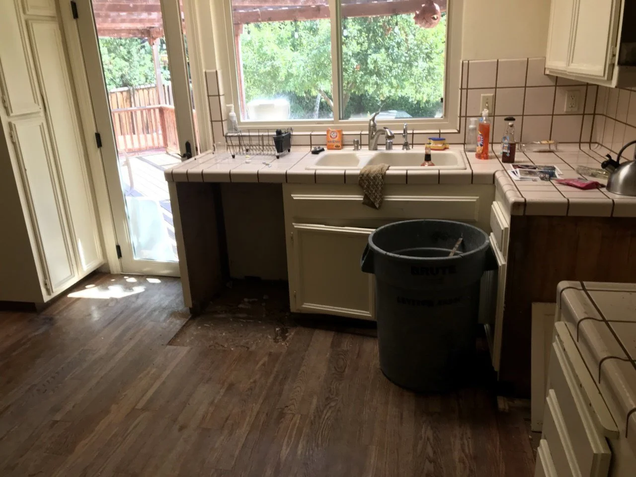 View of the original kitchen prior to renovation, showing dated finishes and compact floor plan.