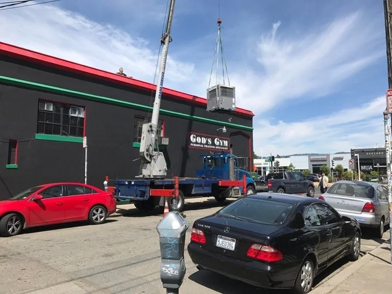 New HVAC unit being hoisted onto roof of BIBO Salon