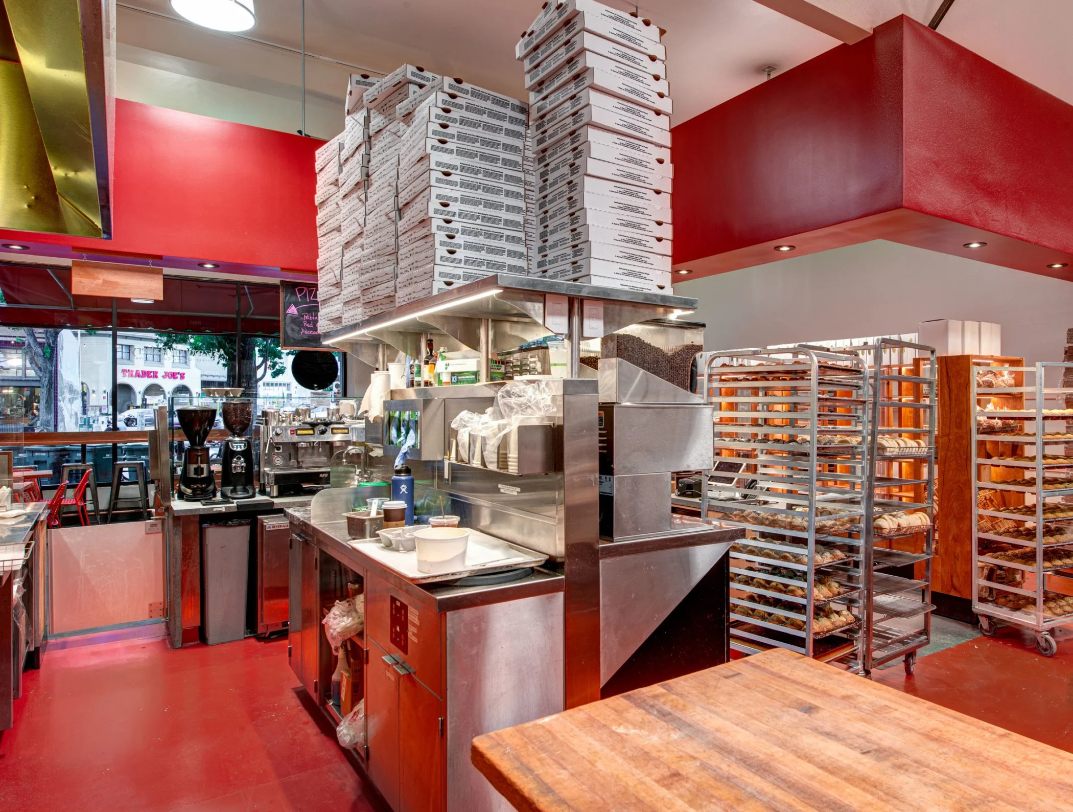 Arizmendi Kitchen Area looking toward front window. Prep stations, pizza boxes and rolling bread racks are ready for work and customers.
