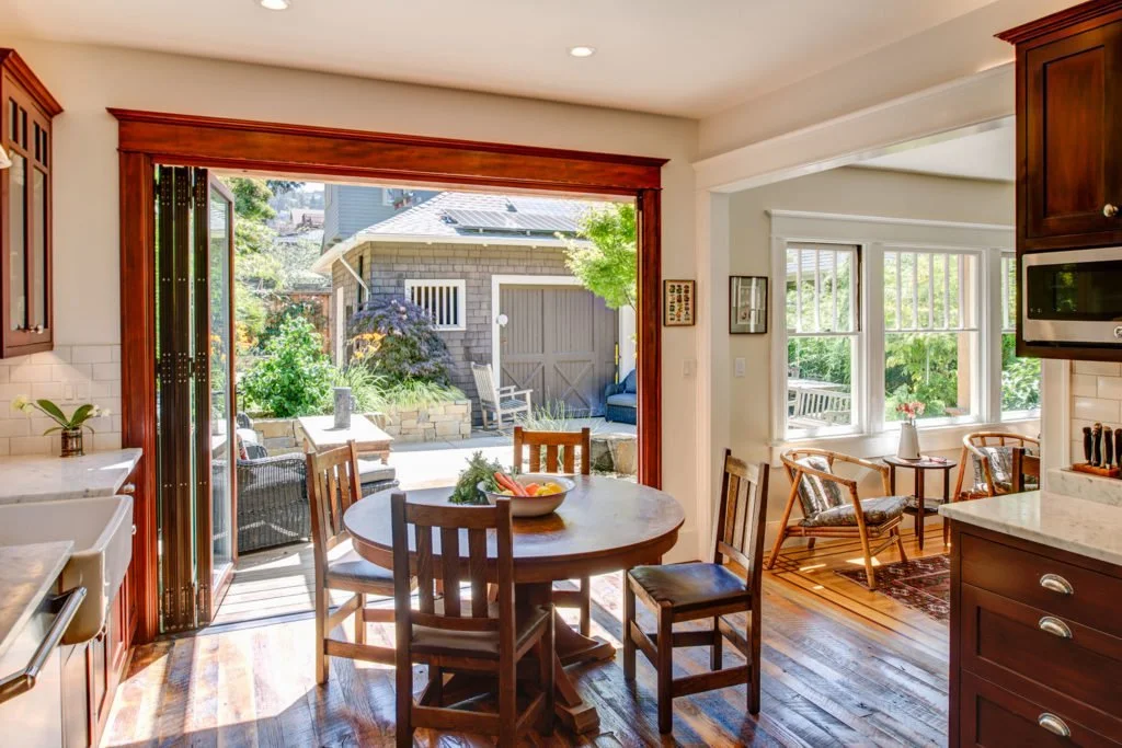 Folding door system opened wide from the kitchen to the redwood deck, creating an indoor outdoor flow and bringing light and fresh air into the room for entertaining.