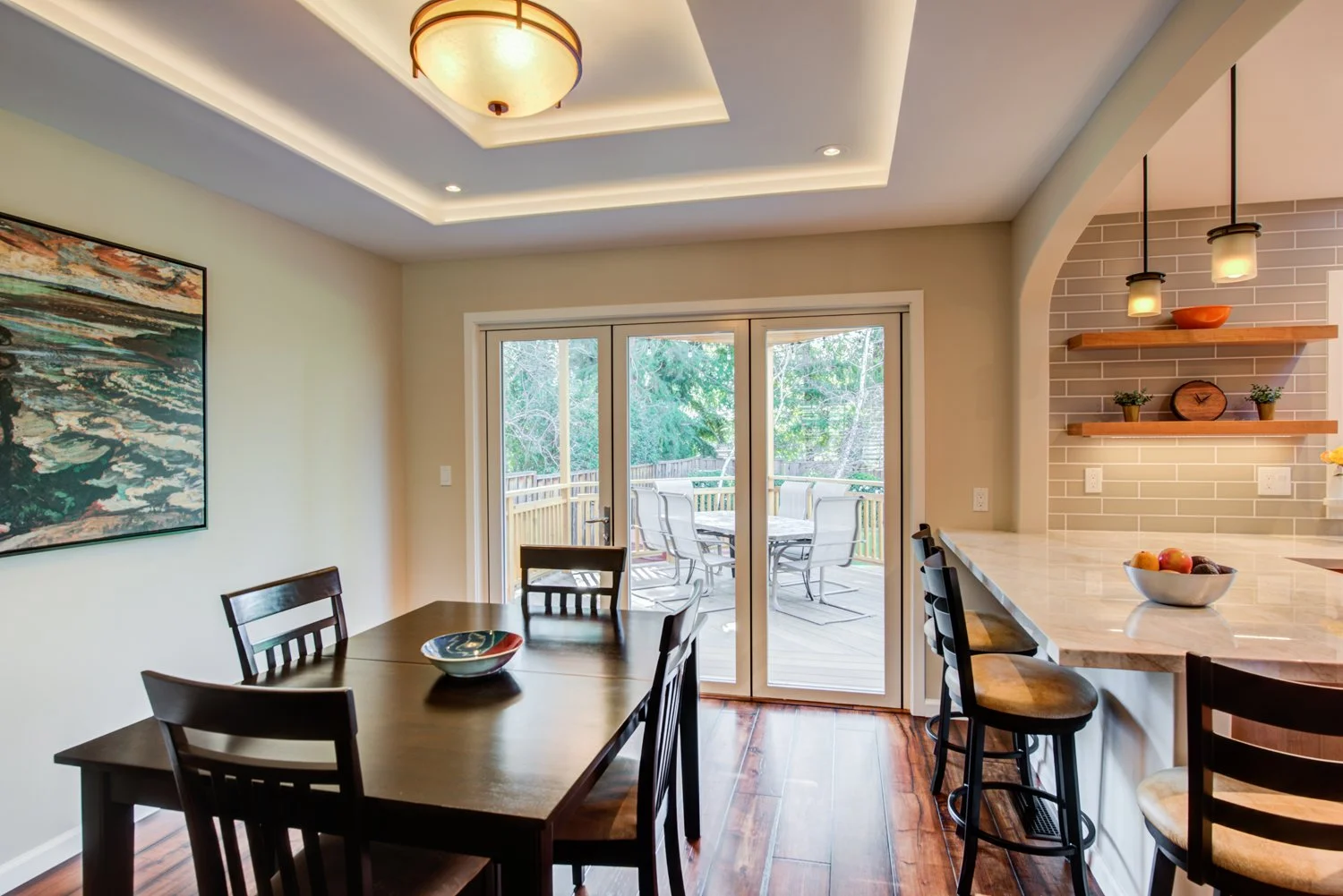 Closed glass doors overlooking the deck, connected to a modern open kitchen.